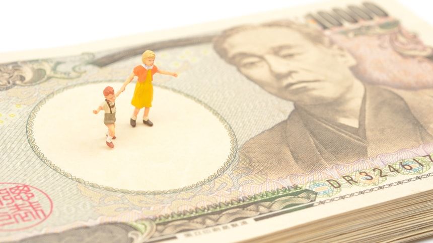 札束の上にある親子の模型