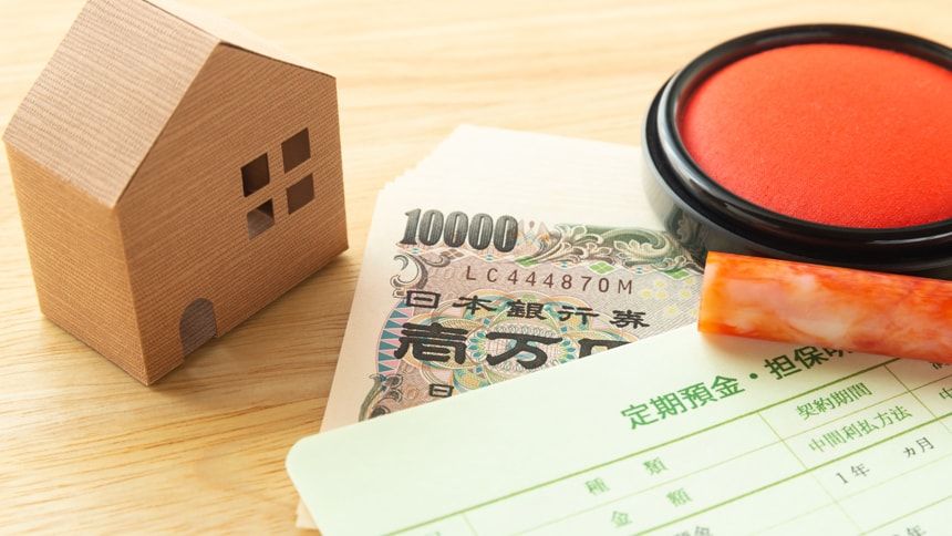 家の模型と通帳と現金と印鑑