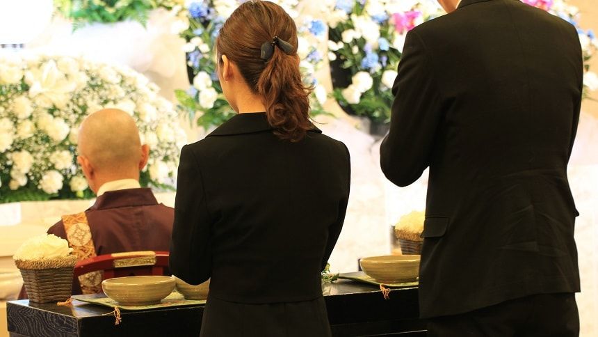 祭壇の前で焼香する男女